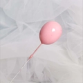 Detalle macro de un adorno para tarta con forma de globo rosa sobre fondo de tul delicado - Rosa