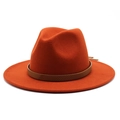 Detail of orange wool fedora hat featuring a brown snakeskin textured leather belt band - Rust red