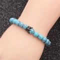 8mm blue turquoise bead bracelet with a black crown charm on a hand model - Blue Turquoise Black Crown White Zircon