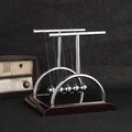 Newton's cradle balance balls with metal frame and dark brown wooden base on desk - Large T-Shape