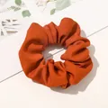 Close-up of caramel plaid fabric scrunchie with thick pleated texture and soft cotton feel - Diagonal Texture Orange Red