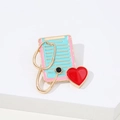 Cartoon enamel brooch featuring a clipboard, golden stethoscope and red medical heart charm - Heart Medical Clipboard