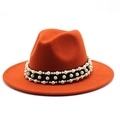 Detail of wool felt fedora hat featuring black ribbon and decorative white pearls - Rust red