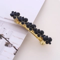 Elegant gold hair clip with dark blue rhinestones on an open magazine display - Dark Blue Rhinestone