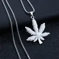 Vue rapprochée d'un collier hip-hop argenté avec pendentif feuille sur fond texturé noir - Feuille d'érable + chaîne en acier inoxydable