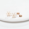 Elegant rose gold snowflake stud earrings with intricate cutout design on white stand - Rose Gold