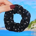 Detailed close-up of a black and white polka dot chiffon hair scrunchie worn on hand - Black Polka Dot