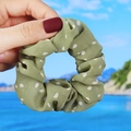 Detailed close-up of avocado green polka dot scrunchie made of sheer chiffon fabric - Green Polka Dot