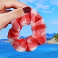 Red and white checkered large scrunchie in sheer fabric held against a blue ocean background - Large Red Plaid