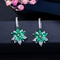 Détail des boucles d'oreilles fleurs avec pierres émeraude et blanches sur monture argent - Vert