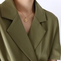 Golden sun and moon medallion necklace on model wearing an olive green suit - Gold (P302-Gold Necklace)