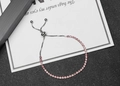 Detail of adjustable silver chain bracelet featuring pink rhinestones and a slider clasp - Pink