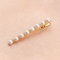 Detailed shot of gold hair clip with white pearls and sparkling crystals on satin - 8 Pearls Rhinestone Hair Clip