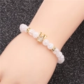 White crackle bead bracelet with a gold crystal crown charm on a glitter background - Large Crown