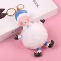 Christmas elf plush ball keychain with red faux fur and green elf hat on pink background - Grandma Santa