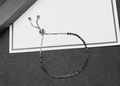 Detail of adjustable slider bracelet with dark red zircons in silver finish chain - Purple