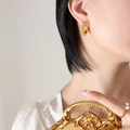 Chic 18K gold plated C-shaped earrings with woven texture on a female model - Gold