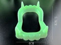 Detailed view of green glowing vampire teeth toy showing dimensions 5.5cm by 4cm - Luminous Green