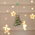 Detail of wooden Christmas tree ornament with layered green wood and a silver bell - Five-pointed Star / Green