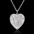 Macro shot of heart-shaped locket pendant with intricate floral engraving and silver finish - Alloy / Hollow Heart / Silver