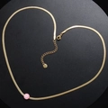Dettaglio della catena a serpente dorata con ciondolo malocchio rosa e chiusura a moschettone - Bianco