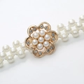 Elegante goldene Blumenbrosche mit weißen Perlen und Strasssteinen an einem Perlen-Taillengürtel - Blume Gold