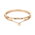 Dettaglio di un bracciale dorato a doppio strato con numeri romani e ciondolo a cuore - Oro (01KC Oro 1885)