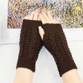Close-up of dark brown cable-knit fingerless gloves with ribbed edges on a book - One Size / Coffee