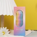 Close-up of wavy pastel birthday candles in six gradient colors with decorative packaging - Happiness Waltz