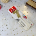 Detail of a champagne gold number 7 birthday candle with metallic finish in packaging - Number 7 / Gold