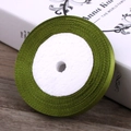 6mm grass green satin ribbon roll made of polyester on a natural wooden background - Grass Green
