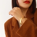Minimalist 18K gold plated stainless steel crossover bangle for women shown on model - Inner Circumference 17cm / Gold