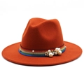 Close-up of pearl and rainbow woven band detailing on an orange wool felt fedora hat - Rust red