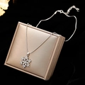 Elegant silver snowflake necklace with crystals on a champagne gift box background - Necklace / Silver