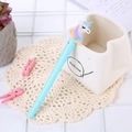 Creative light blue unicorn gel pen with colorful hair resting on a ceramic holder - Light-up Rouge Unicorn Blue