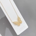 Detailed close-up of golden hollow butterfly pendant necklace with sparkling cubic zirconia - Stainless Steel / Gold White
