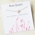 Detailed close-up of rose quartz stone on gold chain with card featuring love and kindness - Rose Quartz