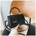 Classic black structured crossbody bag with gold hardware and top handle on a wooden chair - Black