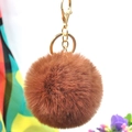 Close-up of fluffy brown faux rabbit fur keychain with a polished gold metal ring buckle - Coffee