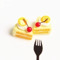 Detailed macro view of two miniature resin triangle cakes with cherry and lemon toppers - Yellow Cherry Cake