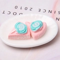Macro detail of miniature resin cake model on a tray with pink and teal cream accents - Pink Lollipop Cake