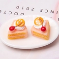 Detailed close-up of resin cake models with pink cream and cherry details on a white plate - Orange Cherry Cake