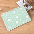 Pastel green floral grid notebook with spiral binding on a warm wooden surface - A5 / Flower