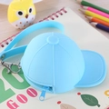 Blue silicone baseball cap coin purse with lanyard on a desk with a notebook - Blue