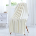 Ivory white coral fleece bath towel with scalloped edges draped on a Nordic chair - 70*140cm / Milky White