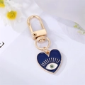 Dettaglio portachiavi a cuore dorato con occhio smaltato blu e design con ciglia - Cuore Blu Reale Occhio Ciglia