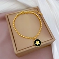 Détail du bracelet à billes dorées avec pendentif étoile noire sur boîte à bijoux - Style Émail Noir Doré (K313)