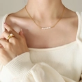 Baroque natural pearl necklace and wide gold ring set worn by a model for a chic look - Gold