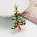 Dettaglio di spilla a albero di Natale in smalto verde con strass colorati su piatto bianco - Z49 Albero di Natale Colorato