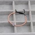 Detail of rose gold beaded woven bracelet with blue micro-inlaid heart charm - Rose Gold